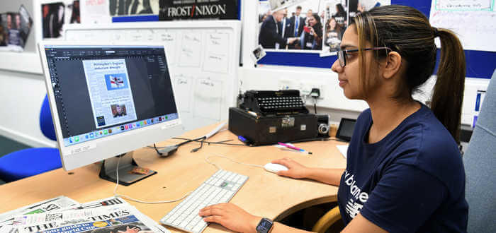student editing newspaper on a computer