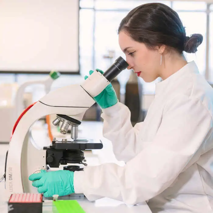 female biomedical sciences student looking into microscope