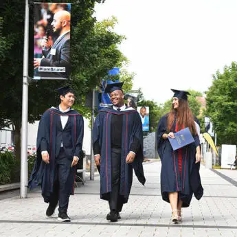 students walking on campus on graduation day