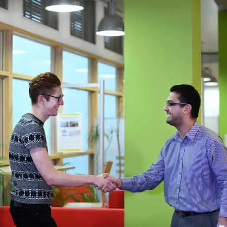 An Economics and Finance student shakes a staff member's hand at the Professional Development Centre