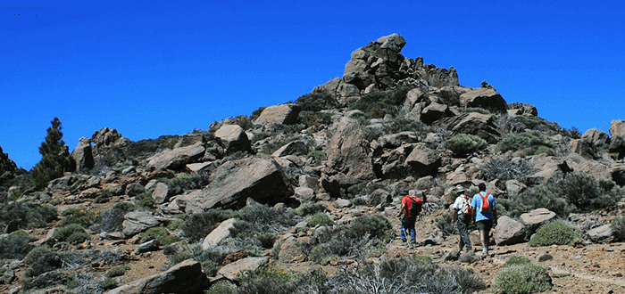 people hiking up rock formations in teide national park tenerife 1