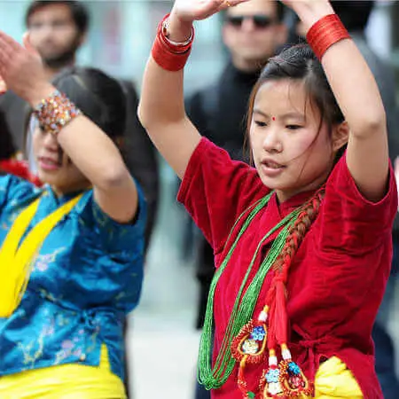 Chinese students dancing in traditional native costumes.