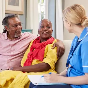 healthcare professional talking to elderly couple