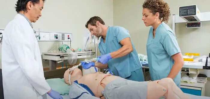 nursing student practicing on clinical mannequin