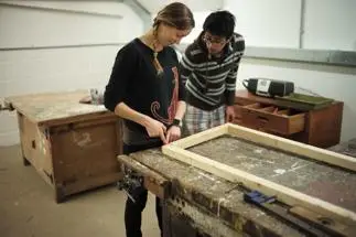 Asian man with woman creating in a workshop