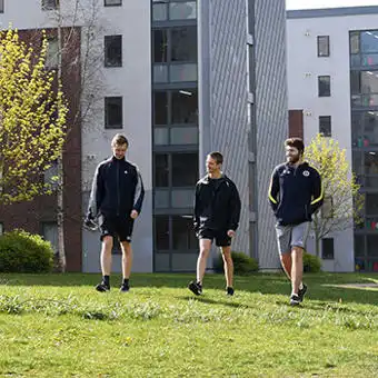 three students walking in a park