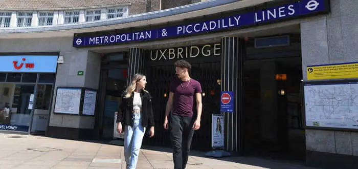 two students walking in fromt of uxbridge underground station