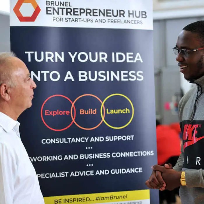 two people standing infront of an entrepreneurship sign