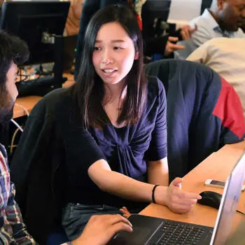 Students using a laptop and talking
