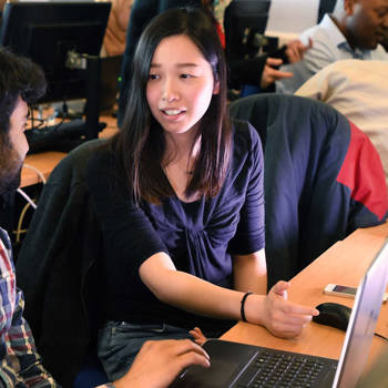 Students using a laptop and talking