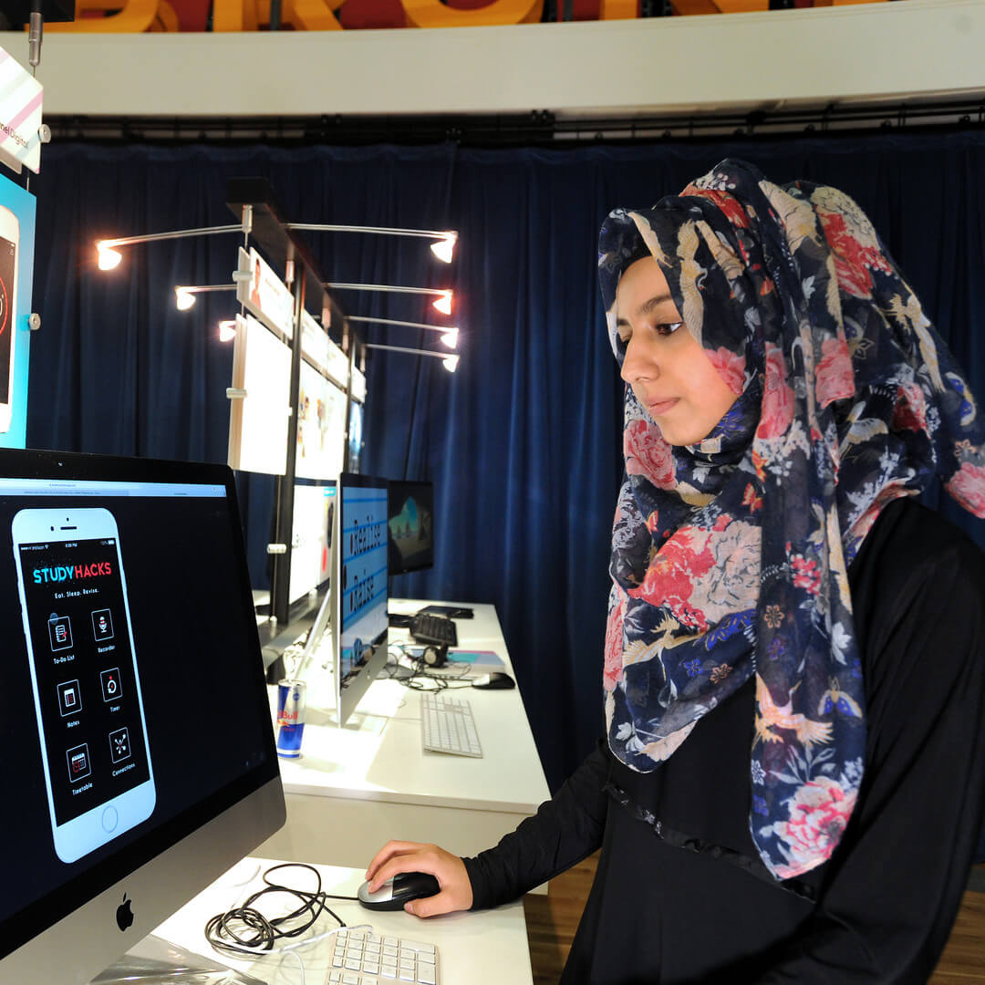 Woman standing on front of a computer and using the pc mouse
