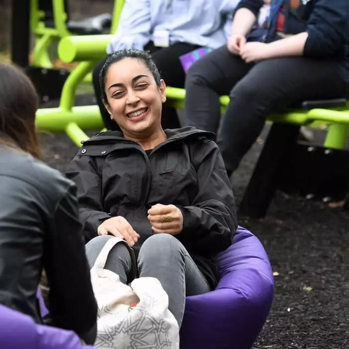 brunel student sitting on bean bag talking to friend