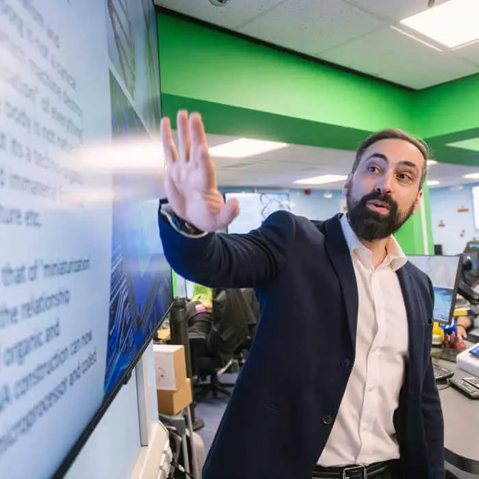 Lecturer pointing at a white board