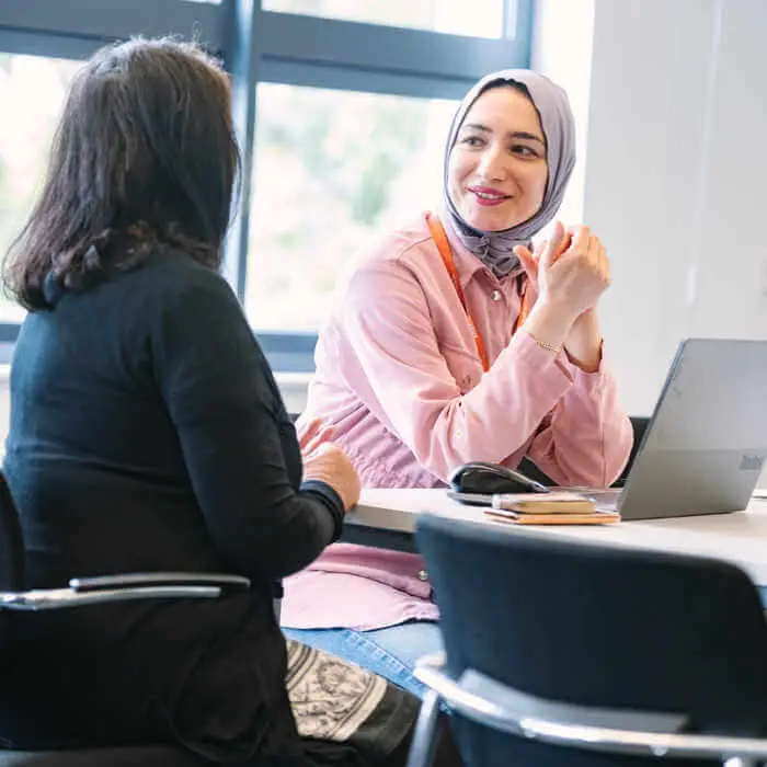 two female students chatting with a laptop