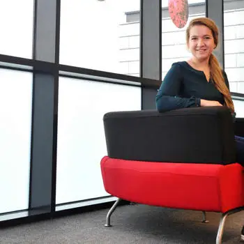 Economics and Finance undergraduate student poses on a red and black chair