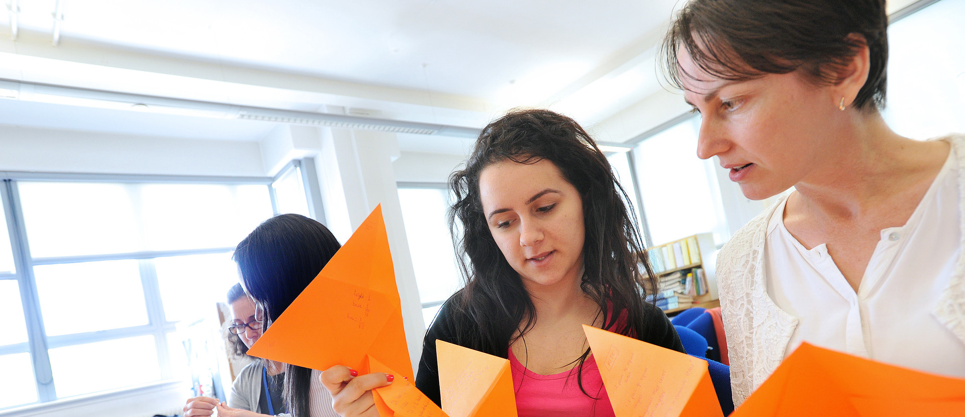 Students holding folded orange cards