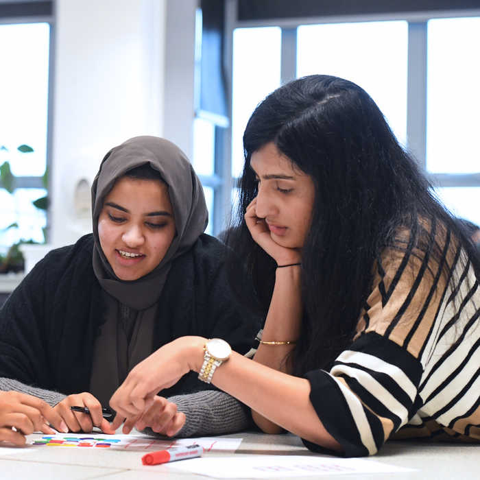 Two female students sitting at desk and reading