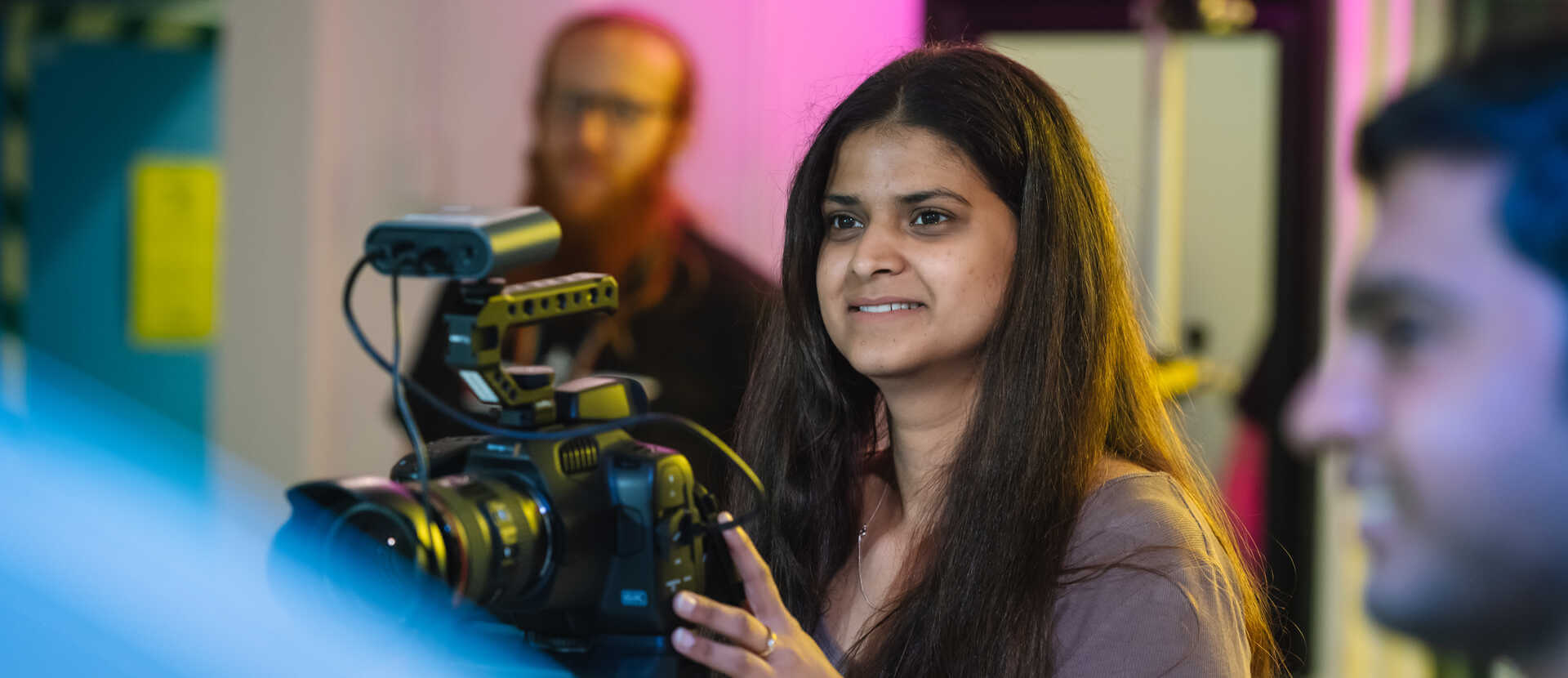 Film student using camera and smiling