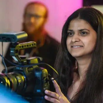 Film student using camera and smiling