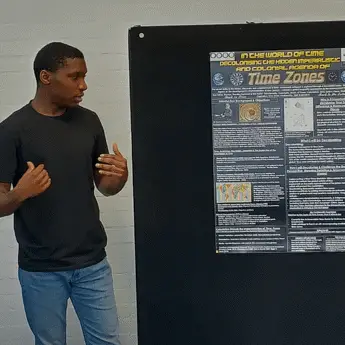 A-student-stands-beside-a-presentation-board