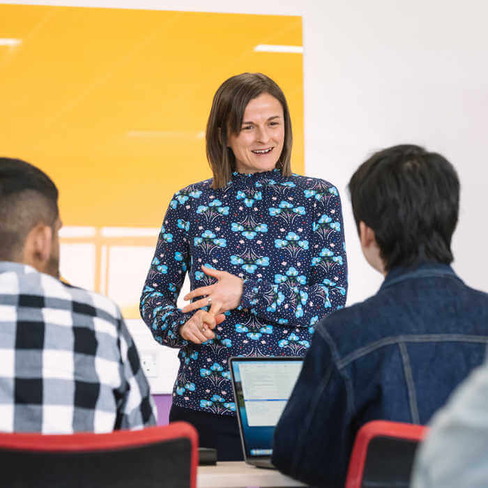 Female academic at the front of the class teaching