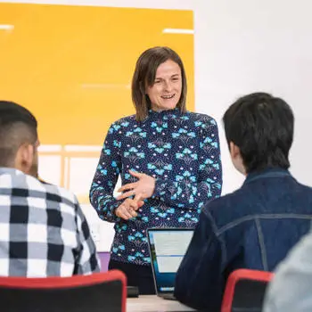 Female academic at the front of the class teaching