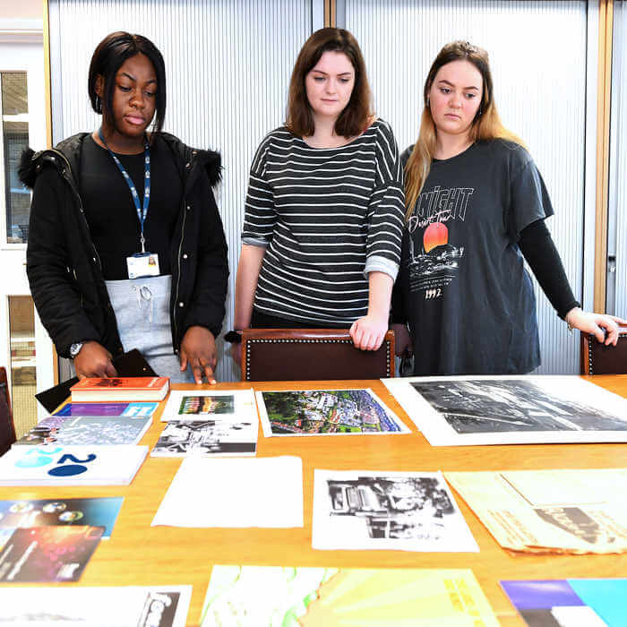 students looking at archives documents on a table