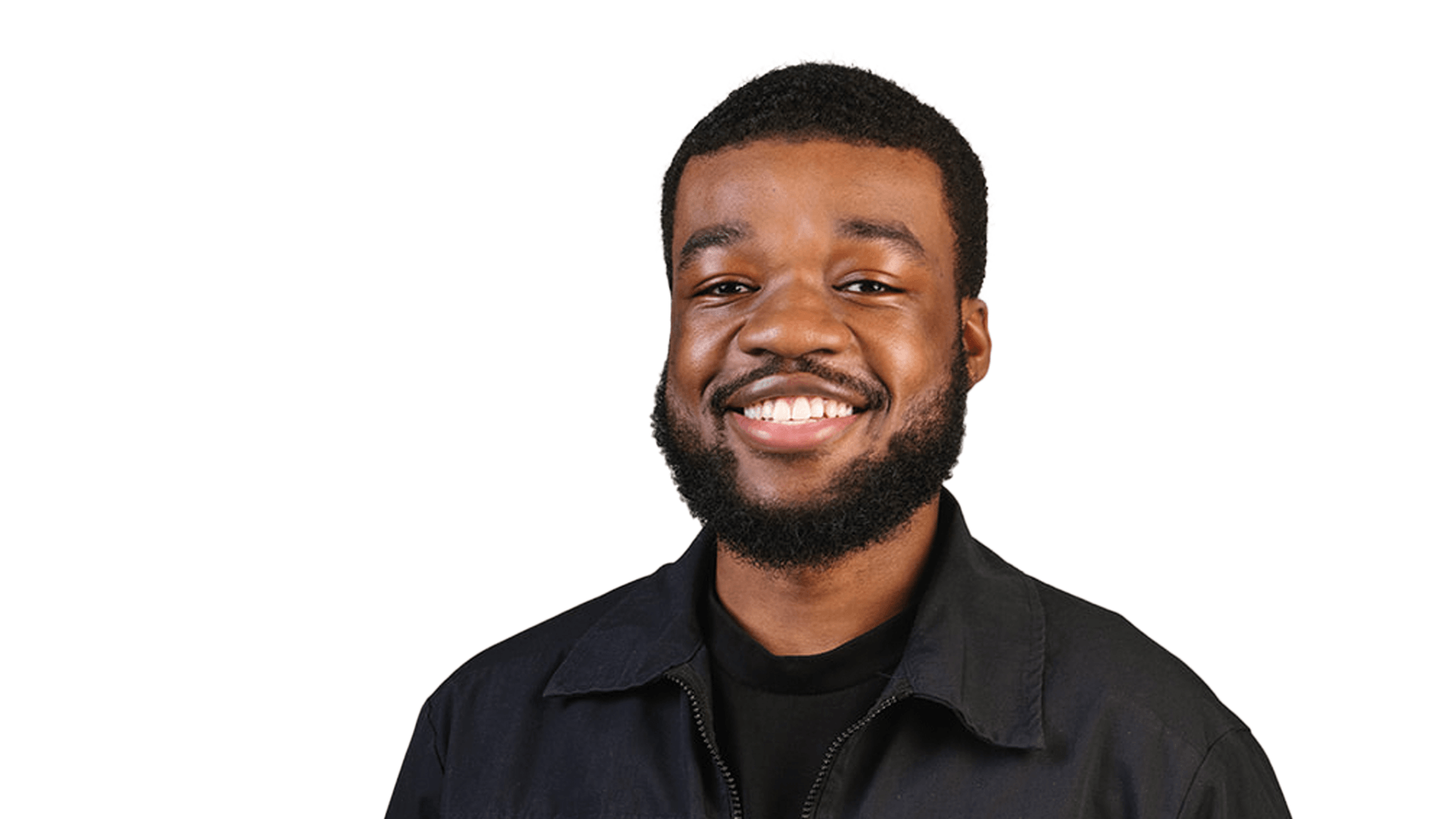 Smiling young Black man with short hair and beard, wearing a black jacket and shirt, against a white background