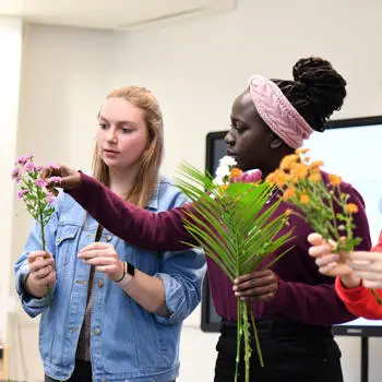 image of two students picking flowers
