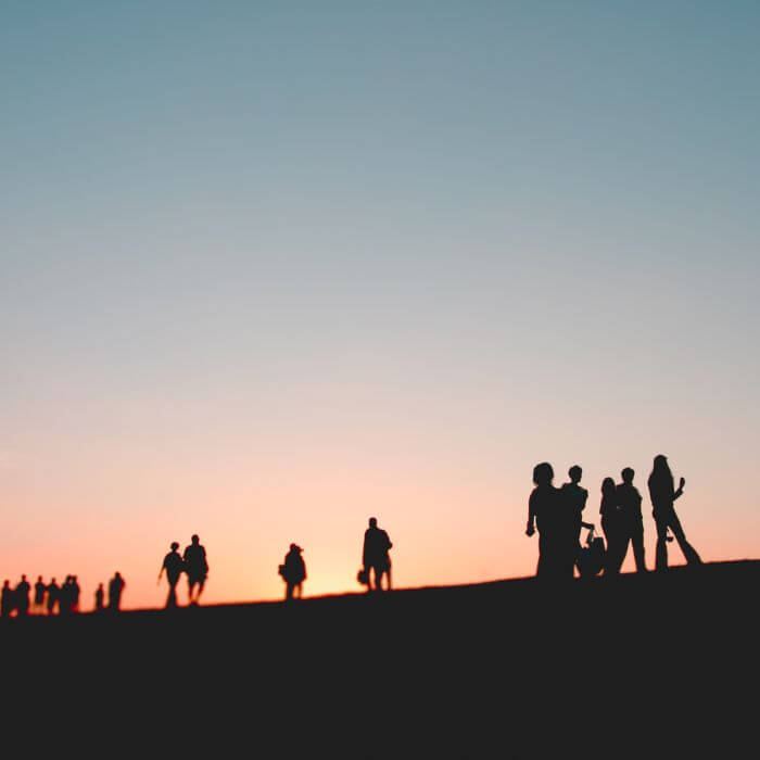 Silhouette of people with sunset on the background