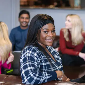 woman sitting with friends smiling into the camera