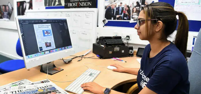 student editing newspaper on a computer