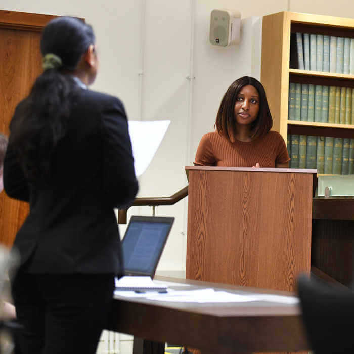 Female student on a podium being questioned by another student