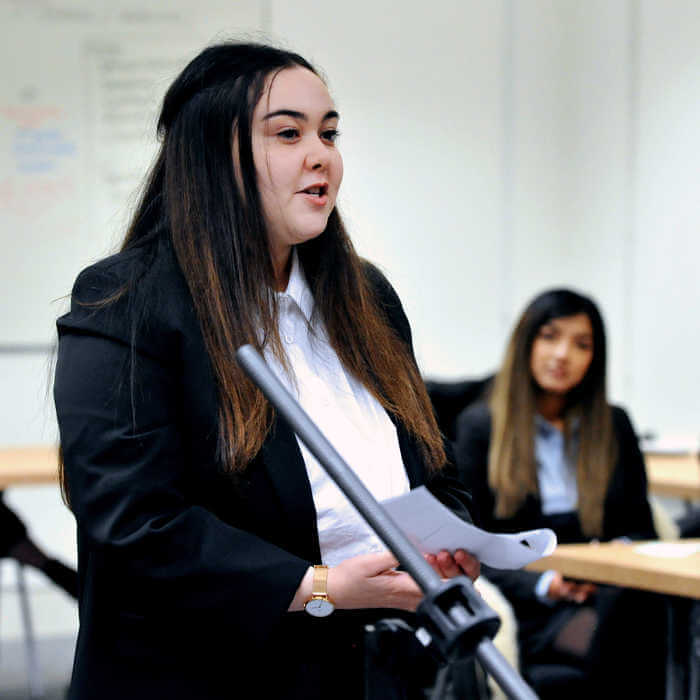 Female student talking in front of a small microphone