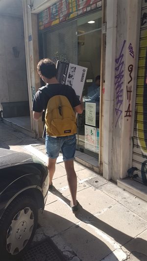 Brunel student carrying musical equipment to donate to a youth centre in Athens