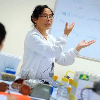 female lecturer in a white coat teaching in a laboratory at Brunel University London