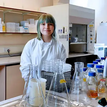 female life sciences student in white coat standing in a laboratory