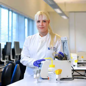 female student in white coat doing experiment in a science lab at Brunel University London