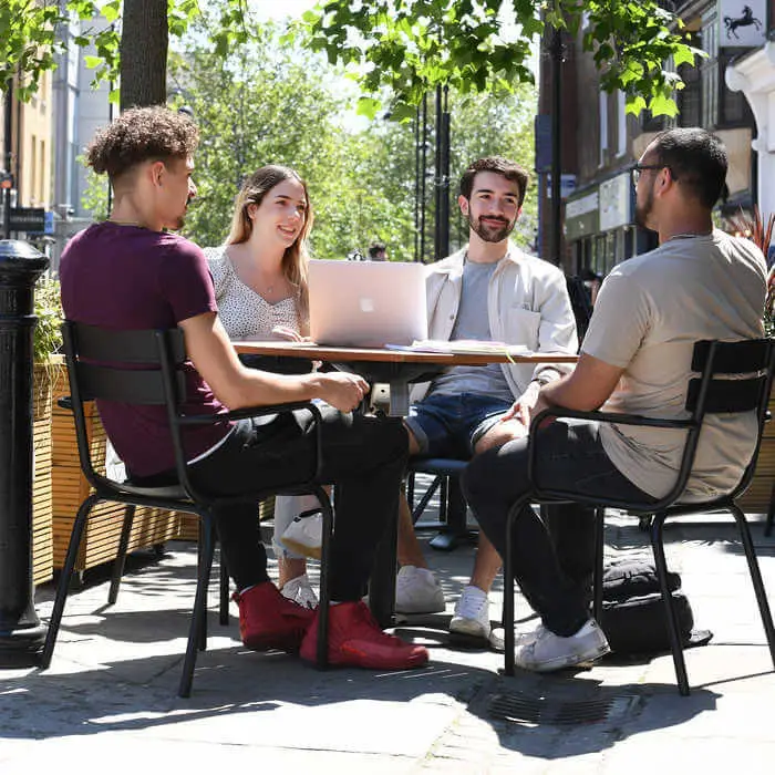students at a table chatting in Uxbridge High Street