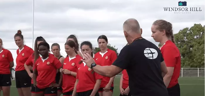 rugby coach instructing female players