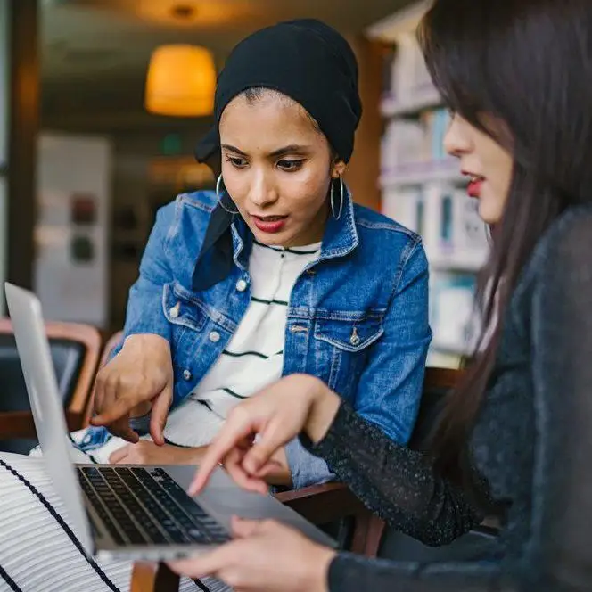 two-women-looking-and-pointing-at-macbook-laptop-1569076 mentatdgt