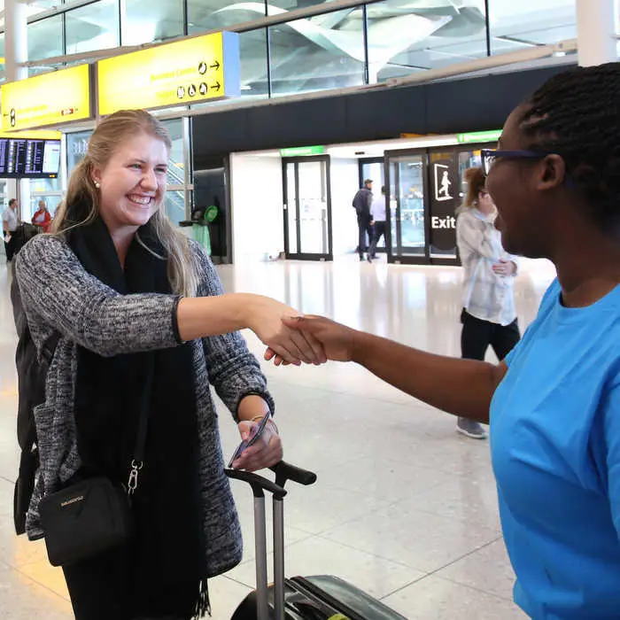International student arriving at heathrow being greeted by student ambassador
