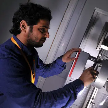 PhD student in structural engineering lab operating machinery