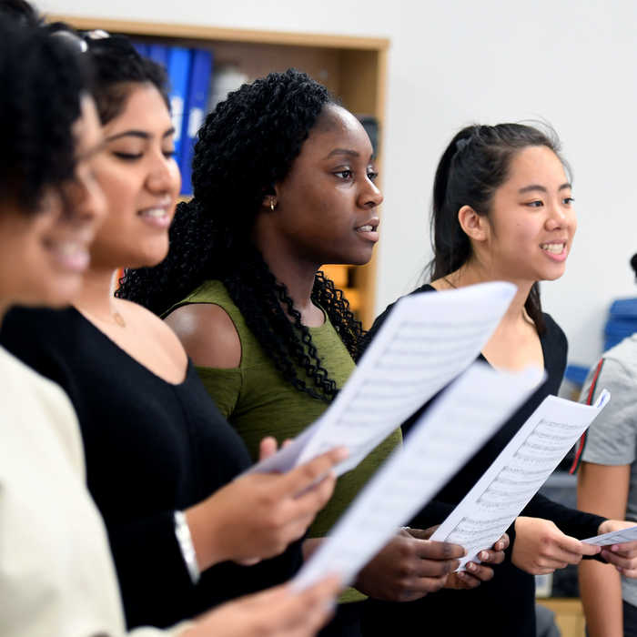 female students holding music sheets