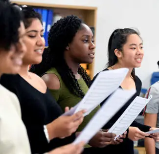 female students holding music sheets