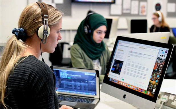 two-female-students-with-headsets-working-on-desktops-Cropped-618x384