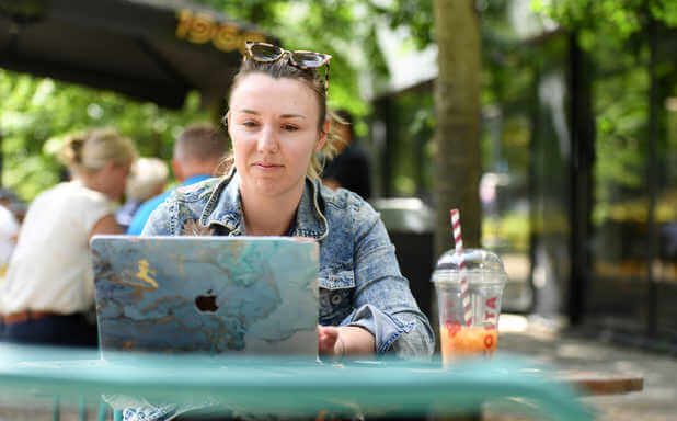 student working on a laptop in a park