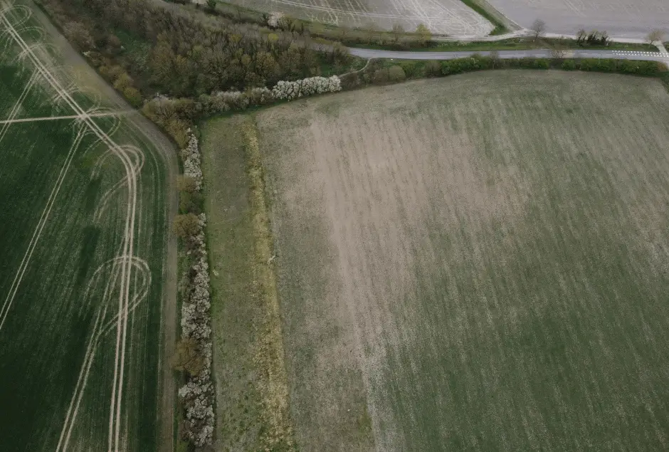 Aerial-view-of-contrasting-agricultural-fields-and-a-winding-road-banner