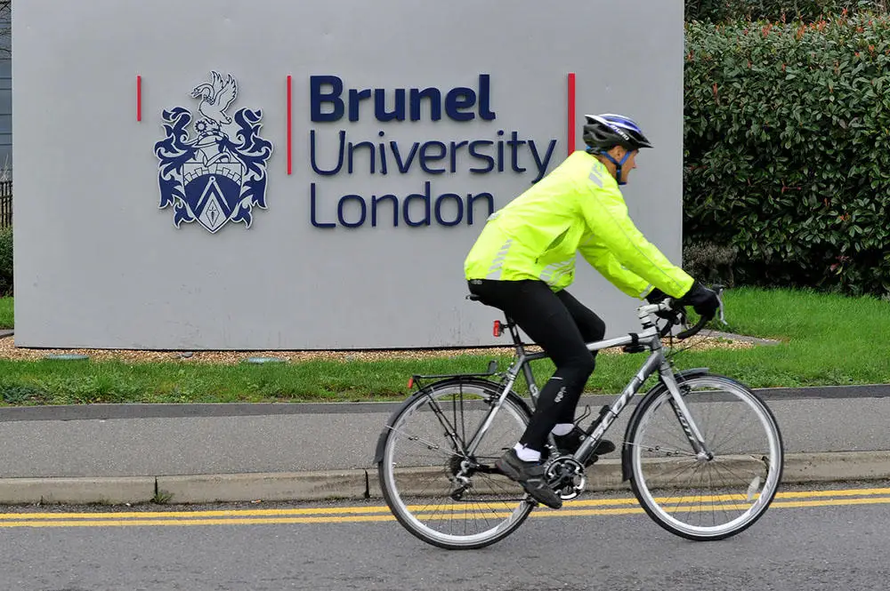 Cyclist passing Brunel sign