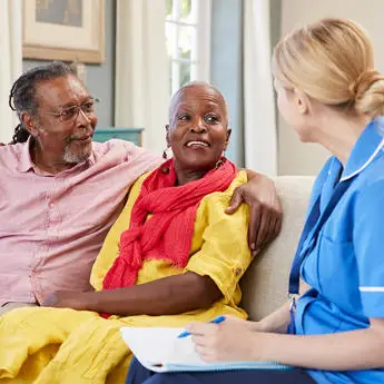 healthcare professional talking to elderly couple